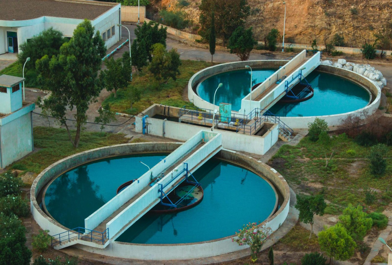 Aerial view of a water treatment plant with circular concrete clarifier tanks